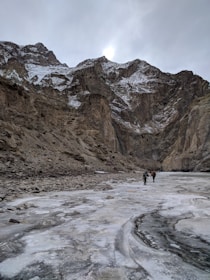 A group of hikers enjoying the sunrise over the desert landscape with snowcapped mountains.