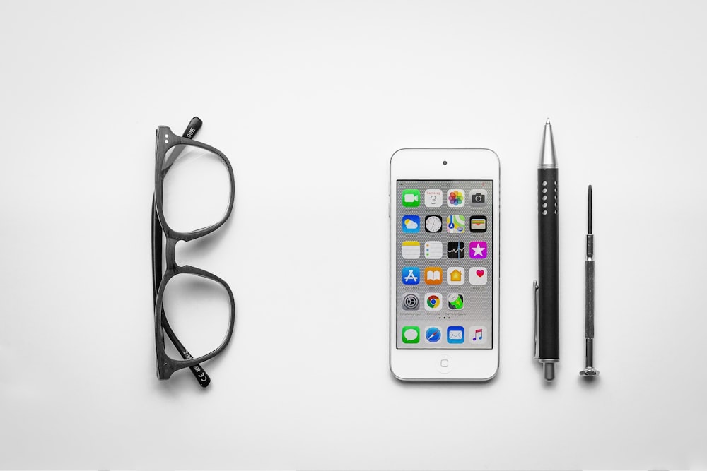 white iPod touch beside click pen