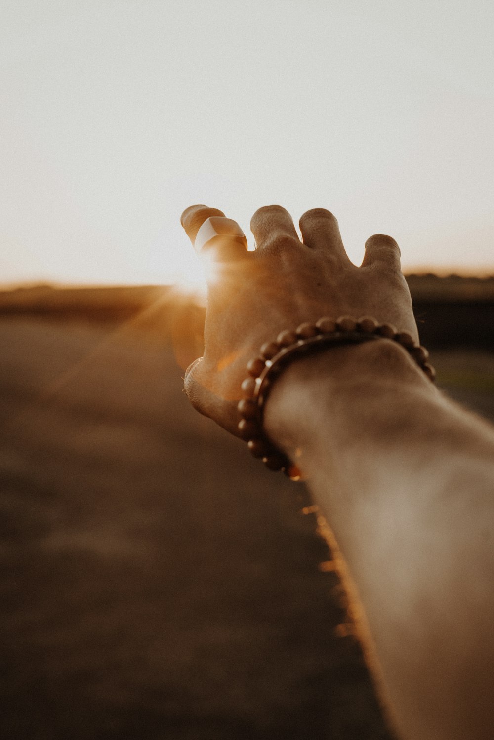 person wearing brown beaded bracelet