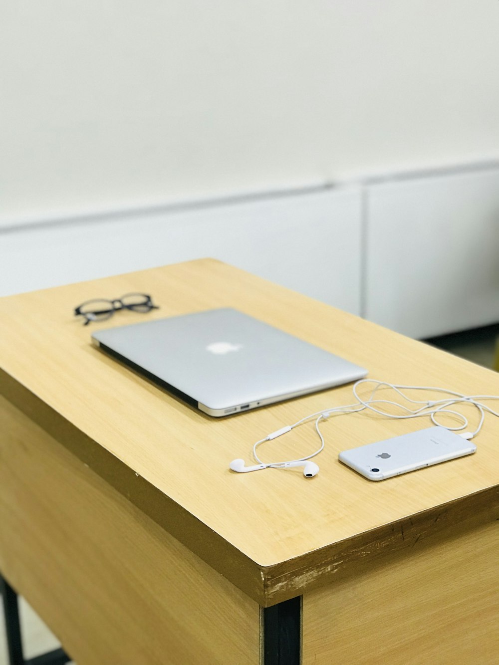 silver MacBook beside eyeglasses and iPhone