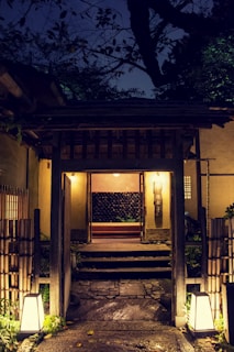 A beautifully lit residential entrance showcasing traditional Japanese wooden elements combined with modern electrical fixtures.