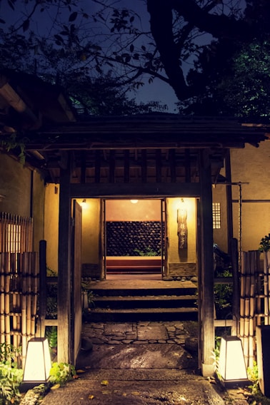 A beautifully lit residential entrance showcasing traditional Japanese wooden elements combined with modern electrical fixtures.
