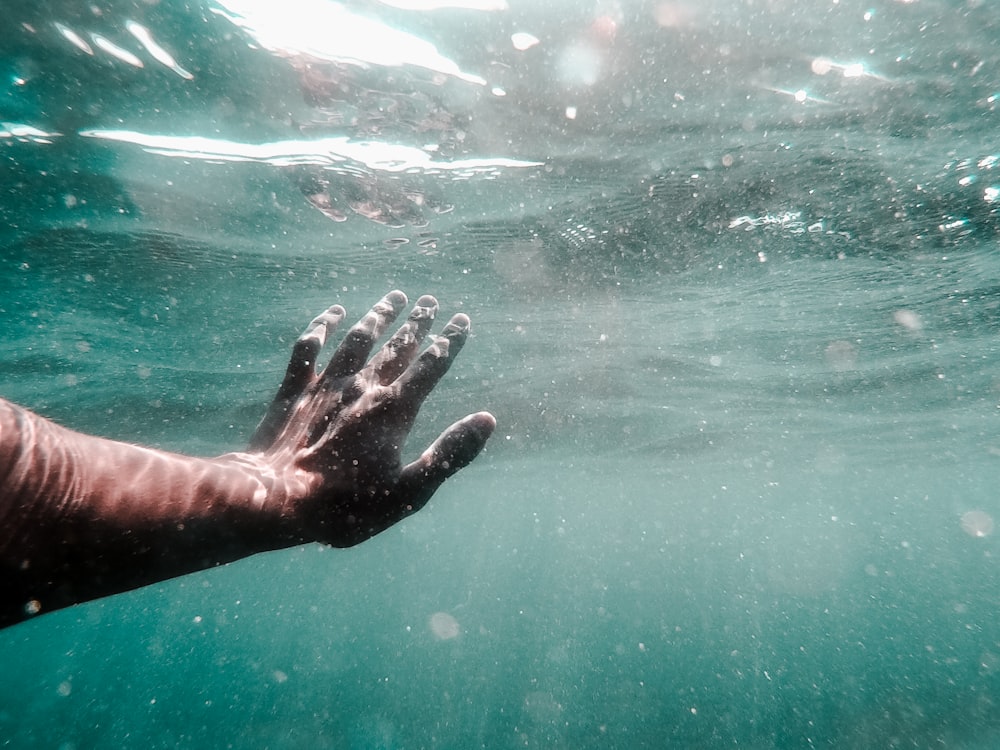 human left hand on body of water