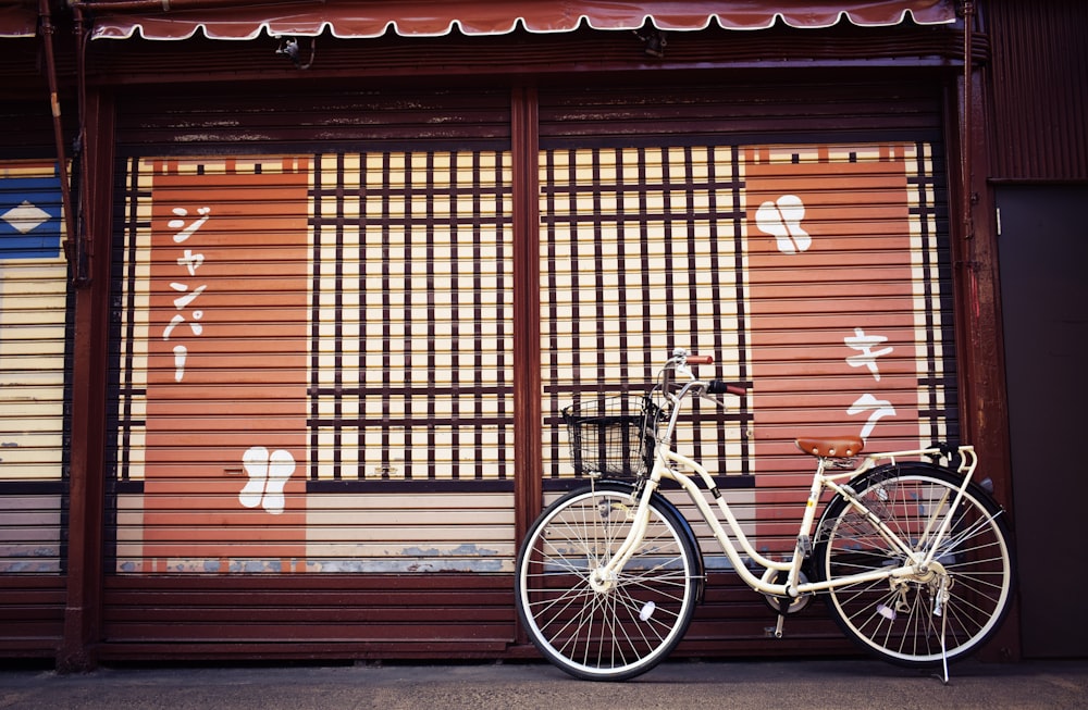 white beach bicycle beside brown and white painted house