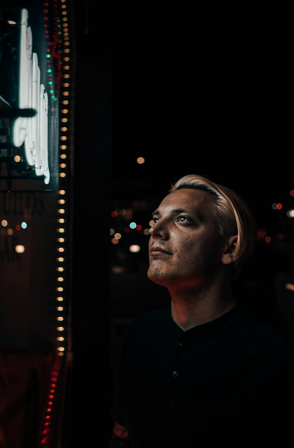 man staring at lighted signage