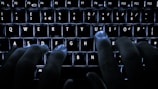 Hands typing on a keyboard with digital interface overlays.