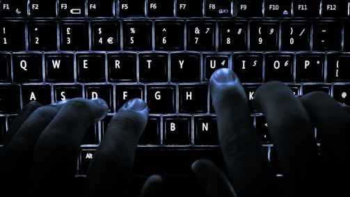 Hands typing on a keyboard with digital interface overlays.