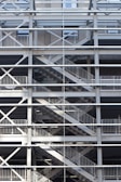 A metal framework consisting of multiple levels, with crisscrossing staircases and railings. The structure is symmetrical and grid-like, providing an industrial appearance.