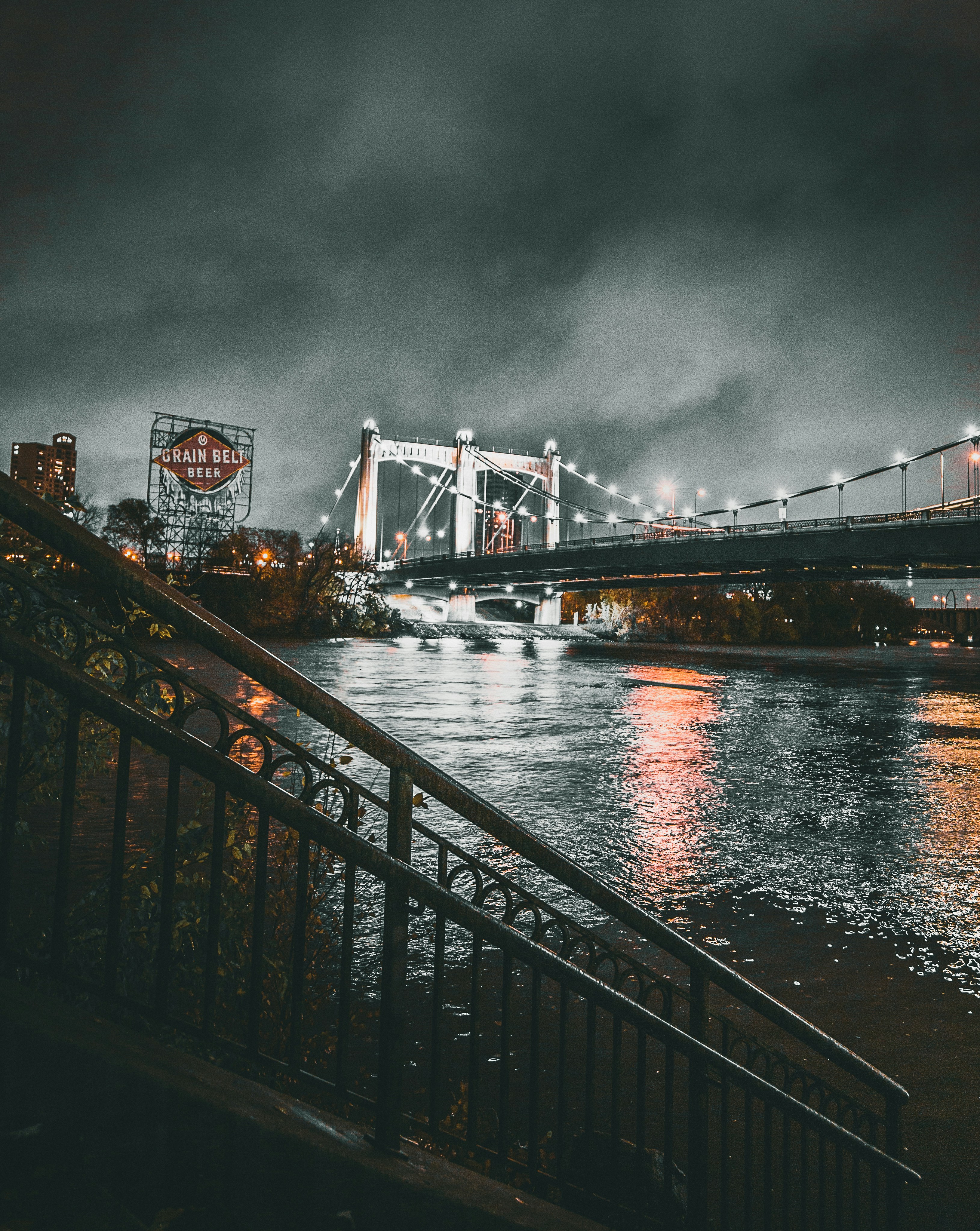 grayscale photo of lighted bridge at night time