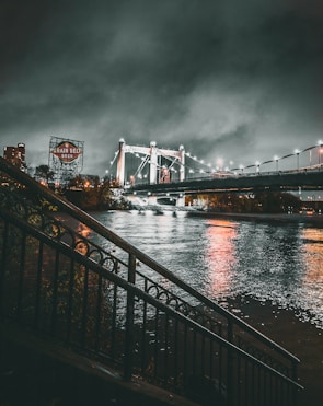 grayscale photo of lighted bridge at night time