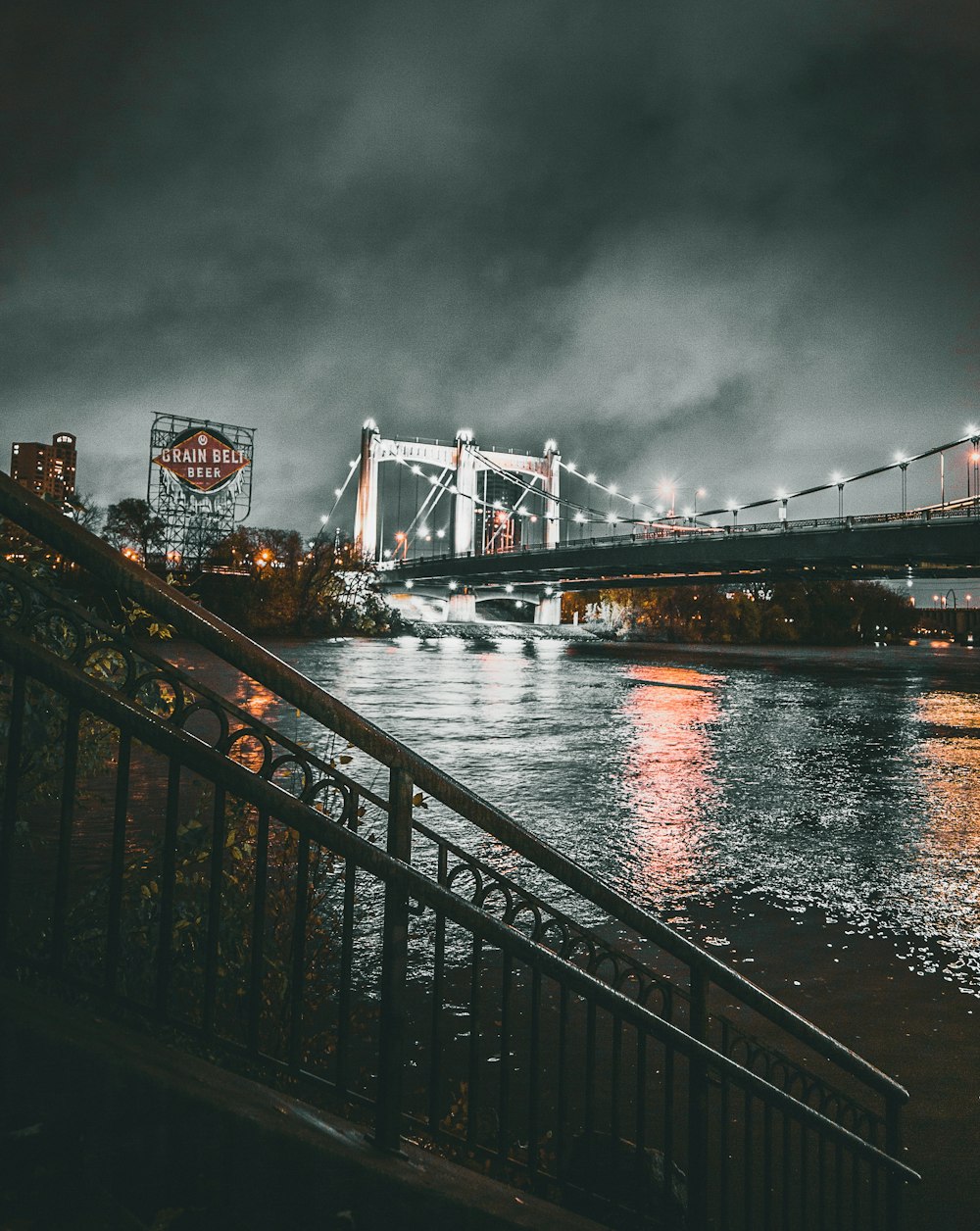 grayscale photo of lighted bridge at night time