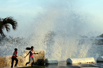 Children playing near the coastline of Acapulco with a backdrop of the city.