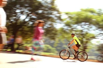 A dynamic shot of a cyclist dressed in Lumina Apparel activewear riding through a leafy city park.