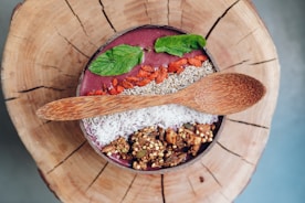 A vibrant smoothie bowl with fresh fruits and nuts on a rustic wooden table