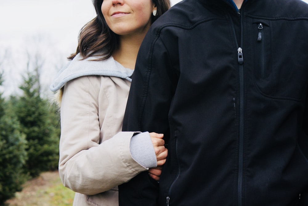 woman holding man near the green plant at daytime