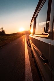 gray vehicle parked on road near tree during golden hour