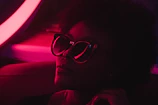 A culturally sharp influencer filming a UGC try-on segment under moody neon lights.