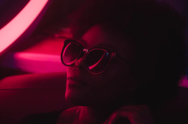 A culturally sharp influencer filming a UGC try-on segment under moody neon lights.