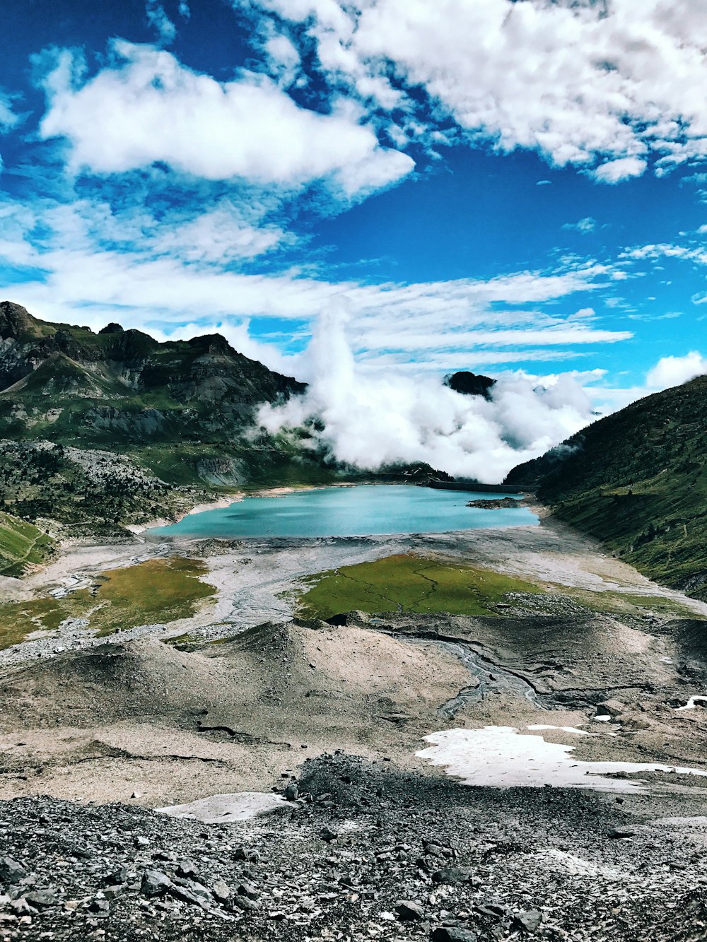 body of water between mountains under cloudy sky