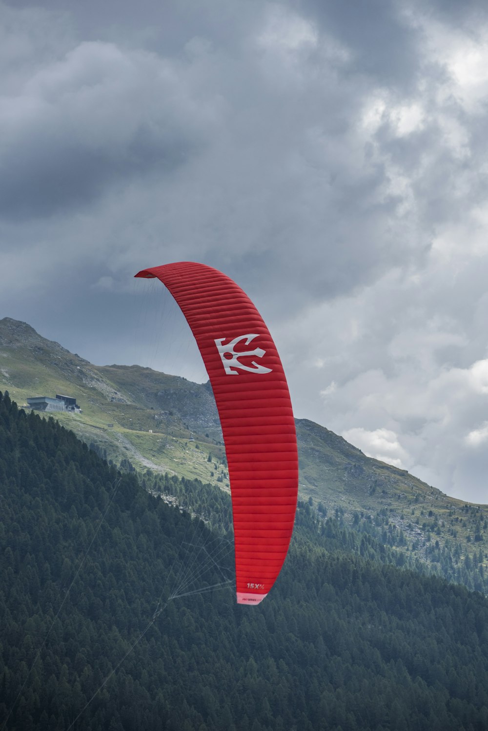 person riding red parachute at daytime