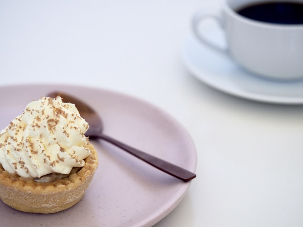 cupcake on white plate beside spoon