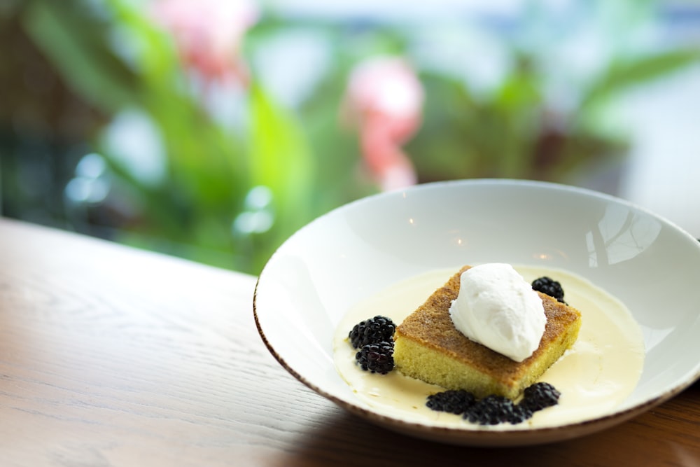 cake with cream in bowl on brown surface