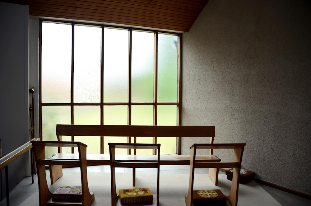 Silla de madera marrón cerca de la ventana de vidrio