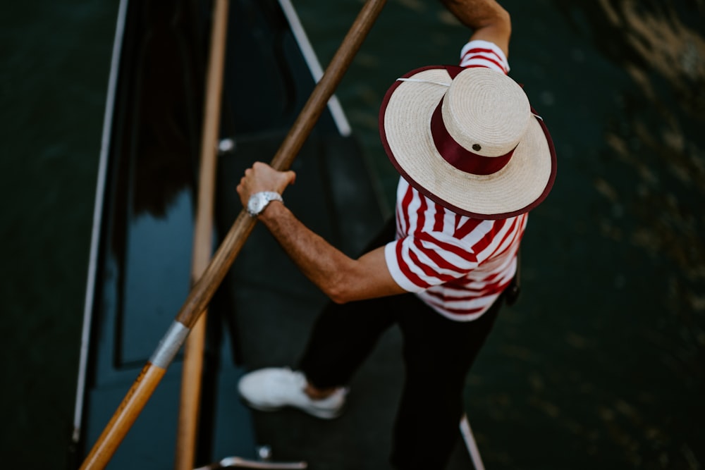 homme debout sur un bateau noir et blanc sur le plan d’eau pendant la journée