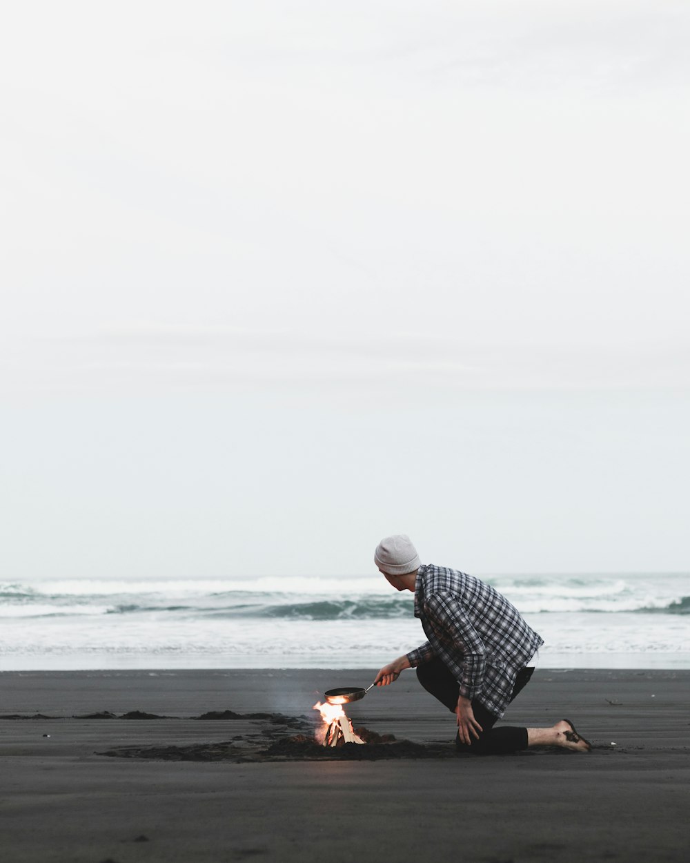 person cooking on seashore