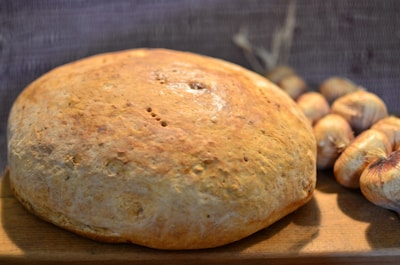 A basket of freshly baked garlic bread on a wooden table.