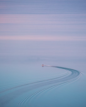 person riding on boat on body of water during daytime