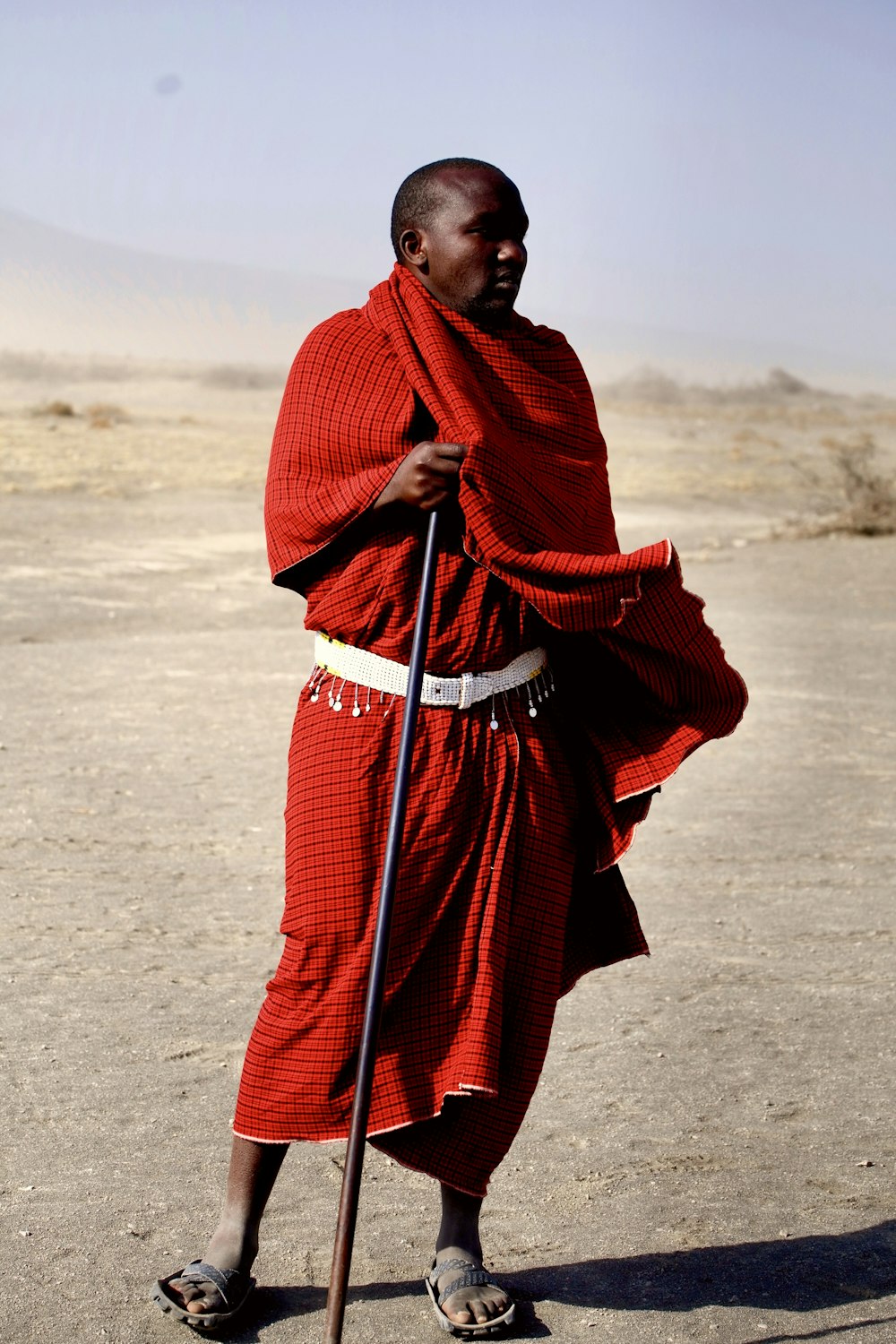 man with black metal rod standing in dessert during daytime