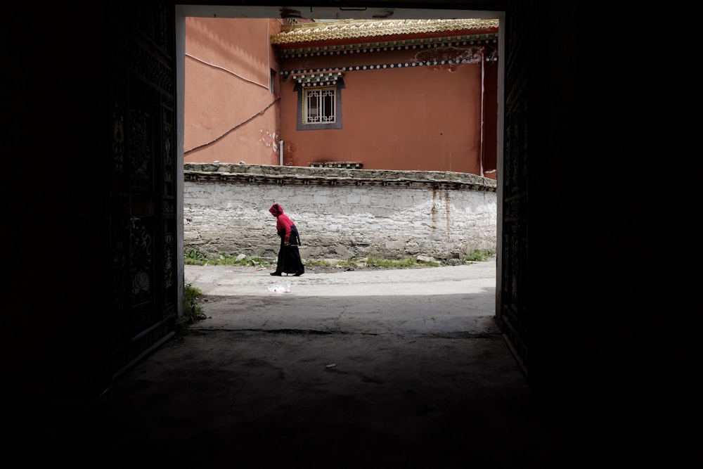 person walking near orange building