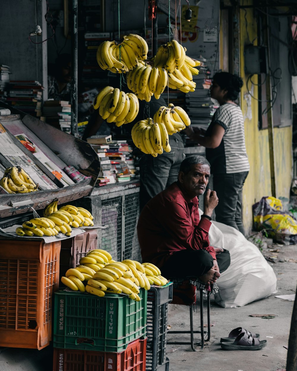 uomo seduto sulla sedia vicino alle banane
