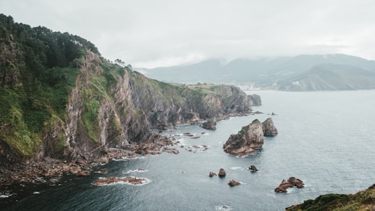 panoramic photography of rock formation near body of water in San Juan de Gaztelugatxe Spain