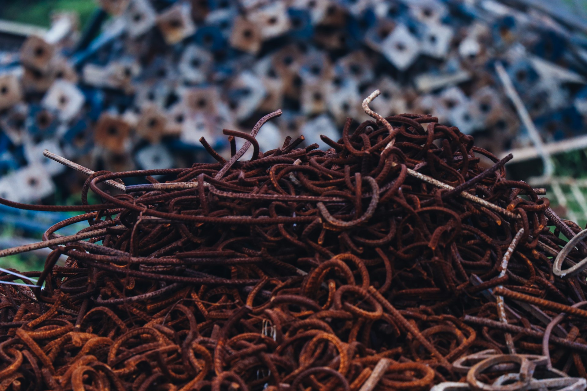 Rusty iron rods and scrap metal pieces arranged in a heap at the metal shop.