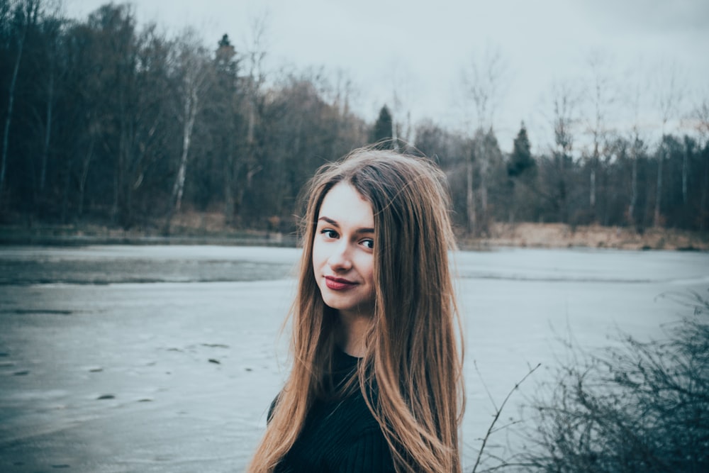 woman in black top near body of water