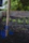 Close-up of a sturdy garden trowel and pruning shears resting on freshly turned soil with green plants in the background.