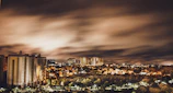 A cinematic shot of a cityscape at night with glowing lights and a dramatic sky, evoking storytelling.