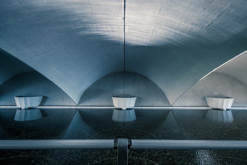 Trois conteneurs blancs à côté d’un mur gris à l’intérieur du bâtiment