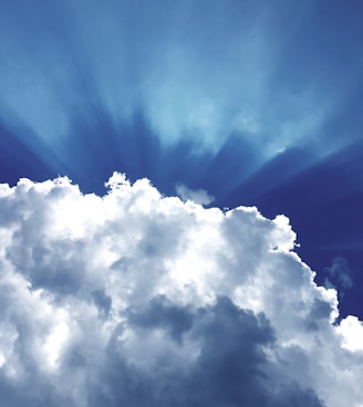 sun rays through white cumulus clouds