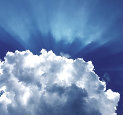 sun rays through white cumulus clouds