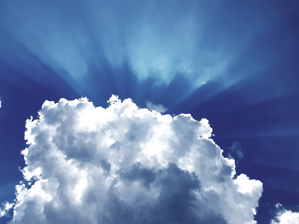 sun rays through white cumulus clouds