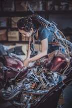 Technician repairing an electric motorcycle in a bright, modern workshop.