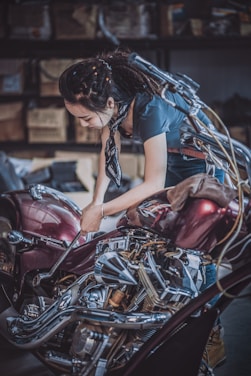 A mechanic working on a motorcycle in a garage.