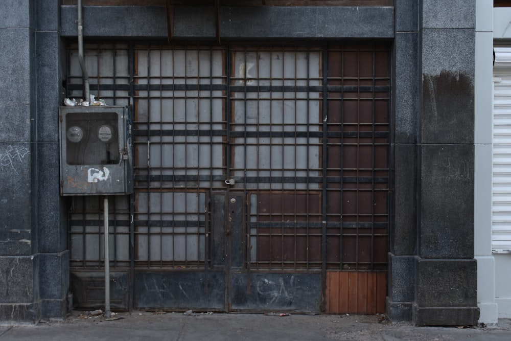 closed gray metal gate of gray building