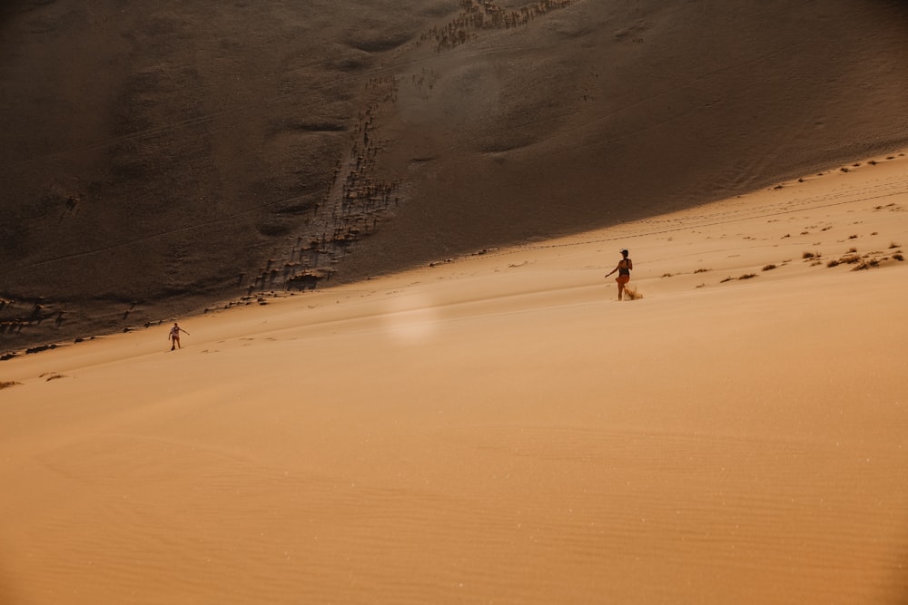 personas que caminan sobre la arena del desierto durante el día