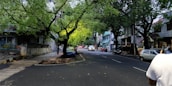 A peaceful street in Geneston with fresh greenery and local residents walking.