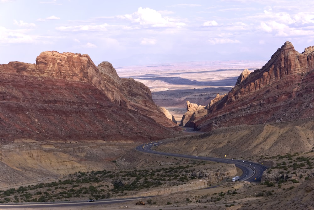 gray asphalt road between brown mountains during daytime