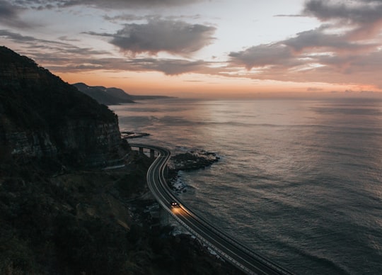 road beside body of water in Sea Cliff Bridge Australia